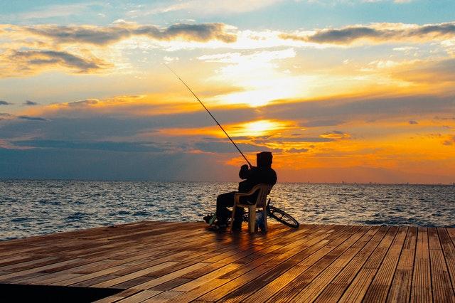 person fishing near large lake