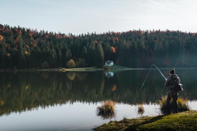 man fishing by lake