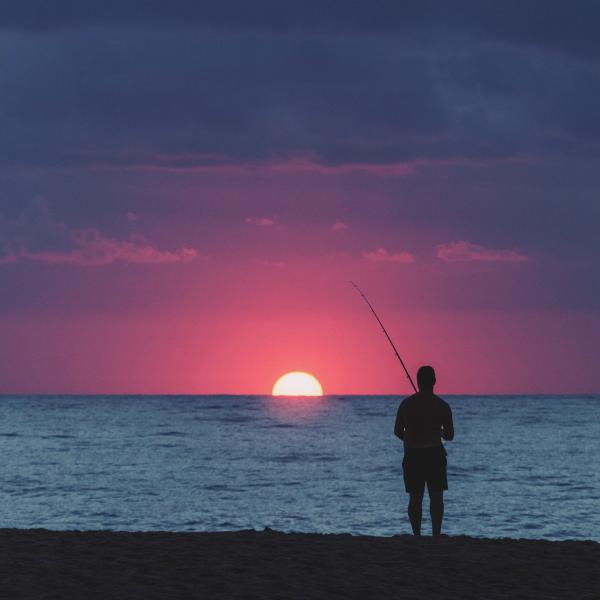 fisherman fishing in the sea at dusk
